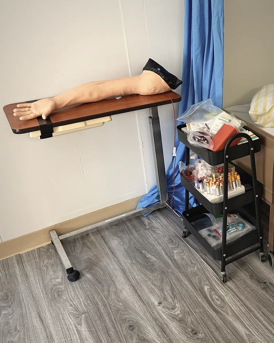 A phlebotomy practice arm and a supply cart in the Mercer Med Tech lab